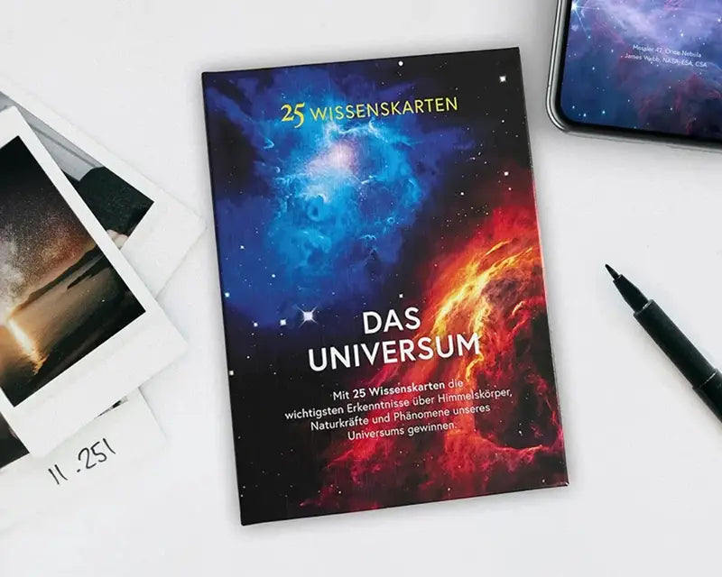 Wissenskarten Das Universum dekorativ hingelegt auf einem Schreibtisch als Denkanstoß im Alltag.